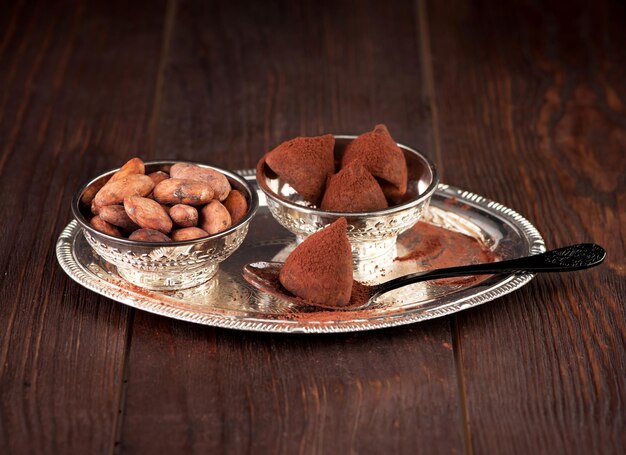 Schokoladentrüffel und Kakaobohnen auf hölzernem backgroundxA