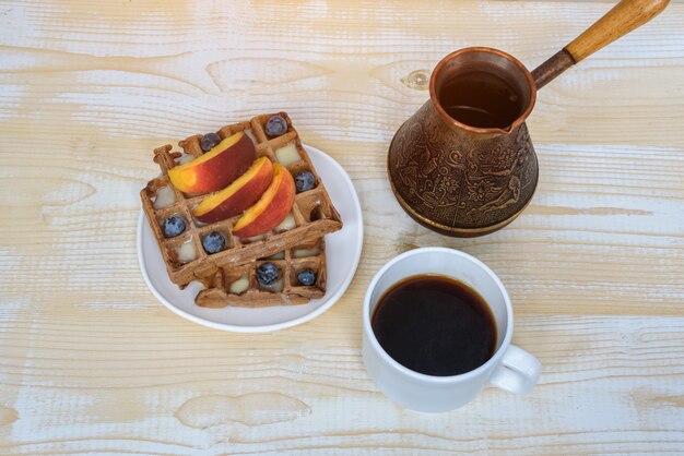 Schokoladenwaffeln mit Früchten und Tasse Kaffee