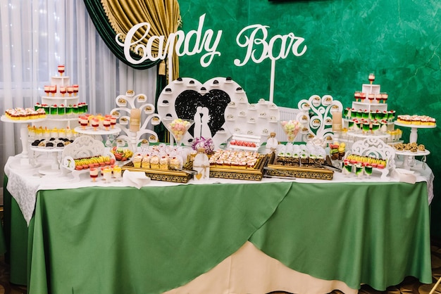 Schokoriegel festlich gedeckter Tisch mit Süßigkeiten Süßigkeiten Desserts Himbeertörtchen und Cupcakes Hochzeitsempfang Törtchen