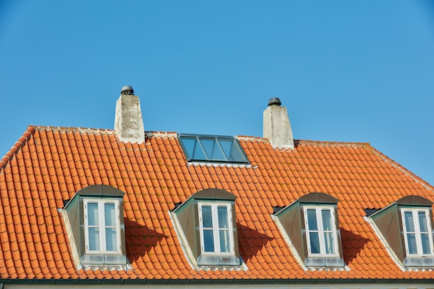 Schornsteinrutschen Fenster und Schiebedach Dachfenster entworfen auf Hausbau draußen vor blauem Himmelshintergrund Bau der Außenarchitektur auf dem Dach für Kaminflucht und natürliches Sonnenlicht