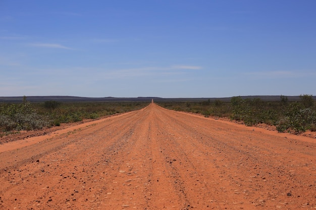 Schotterstraße aus rotem Sand Outback Road Straße zum australischen Busch Remote Outback Road