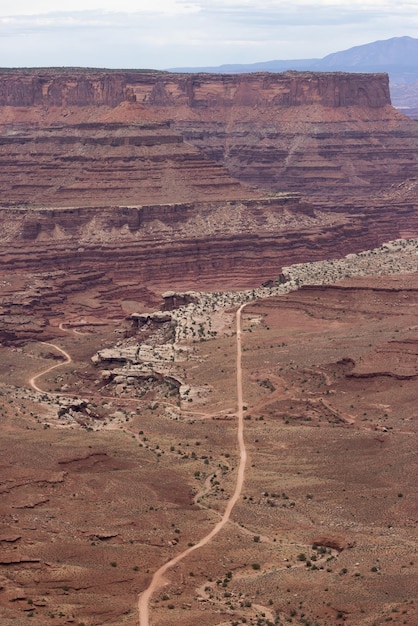 Schotterweg in der Wüstenschlucht mit malerischer amerikanischer Landschaft und roten Felsenbergen