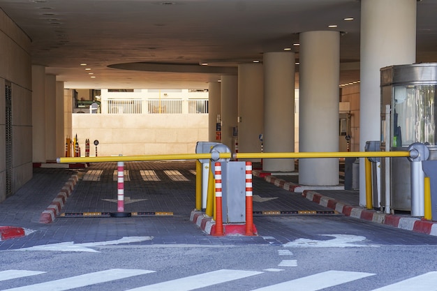 Schranke bei Ein- und Ausfahrt eines PKW-Parkhauses. Schranke auf einem Parkplatz. Ausfahrt aus der Tiefgarage. Tiefgarage, Garage. Innenraum des Parkplatzes