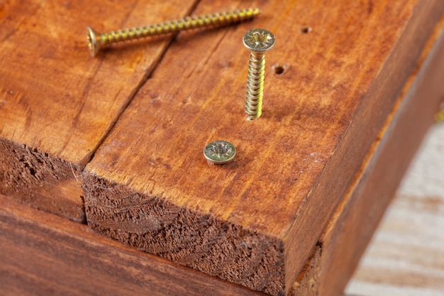 Schrauben an einem Holztisch