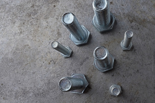 Schrauben verschiedener Größen auf einer Metalloberfläche ausgelegt. verschiedene Nahaufnahmen.