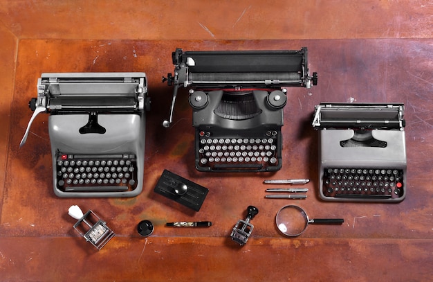 Schreibmaschinen, Stempel und Stifte auf hölzernem Schreibtisch