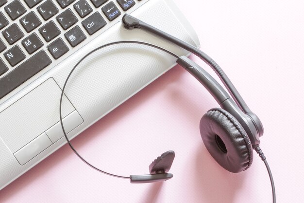 Foto schreibtisch mit headset und tastatur auf rosa hintergrund telearbeit fernbedienung