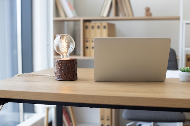 Schreibtisch mit Laptop und Lampe im Innenbereich des Home Office