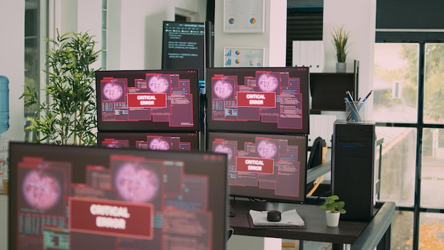 Schreibtisch mit mehreren Monitoren, die Fehlermeldungen auf dem Bildschirm anzeigen, Computerserver wird gehackt. Leeres Büro der Softwareentwicklungsagentur mit Systemfehlersicherheit und Hacking-Alarm.
