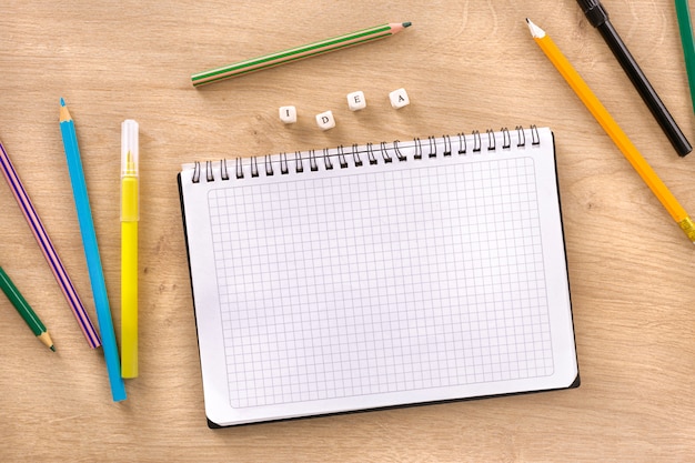 Schreibtisch mit Notizbuch, Wortidee und farbigen Markierungen und Bleistift-Draufsicht