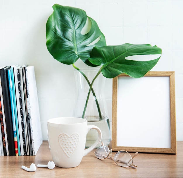 Schreibtisch mit Stapel Notizblöcken, Büromaterial und Zimmerpflanzen