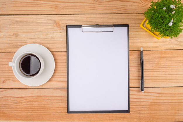Schreibtisch Schreibtisch mit Stift, Tastatur auf Notebook, Tasse Kaffee und Blume. Draufsicht mit Kopie Raum (selektiven Fokus).
