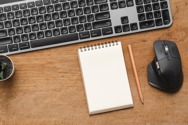 Schreibtischtisch aus Holz mit leerem Notizbuch mit Bleistift-Keybourd-Computer und Zubehör