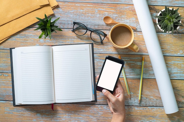 Schreibtischtisch mit ComputertastaturKaffeegläser und Handschrift auf leerem Notizbuch