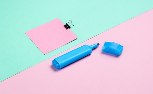 Schreibwaren Büromaterial. Büroklammer, Filzstift, Memo Papier auf rosa blau Pastell den Hintergrund