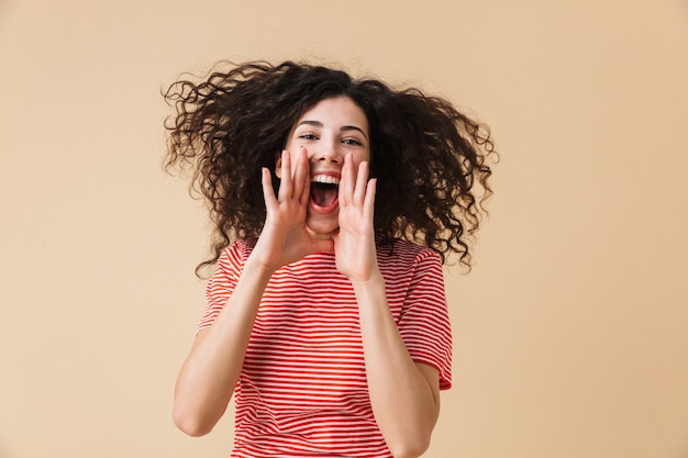 Schreiende junge Frau lokalisiert über beige Wand.