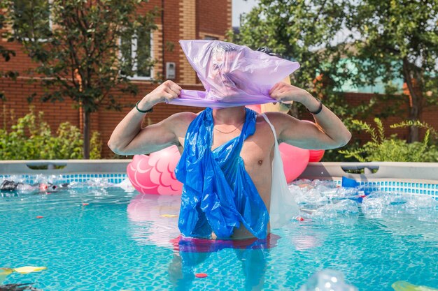 Schreiender Mann mit einer Plastiktüte über dem Kopf in einem schmutzigen Schwimmbad.