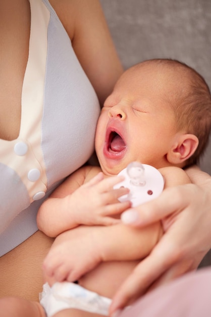 Schreiendes Neugeborenes in den Armen der Mutter