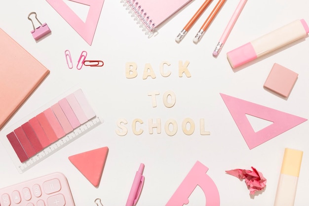 Schriftzug zurück zur Schule auf rosa Hintergrund mit Schulmaterial