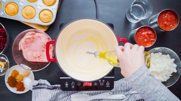 Schritt für Schritt. Ansicht von oben. Puten-Chili in einem holländischen Ofen mit emailliertem Gusseisen kochen.