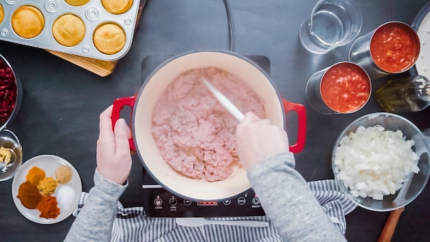 Schritt für Schritt. Ansicht von oben. Puten-Chili in einem holländischen Ofen mit emailliertem Gusseisen kochen.