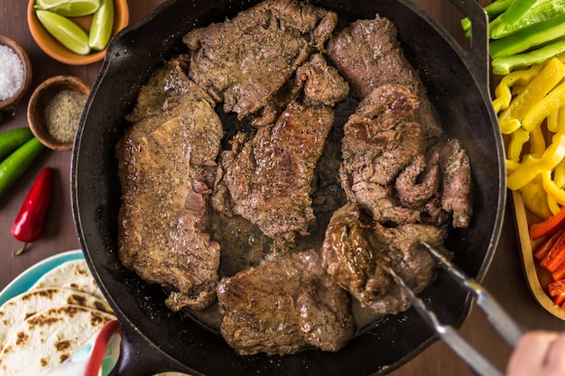 Schritt für Schritt. Braten von Rinderflankensteak in einer gusseisernen Pfanne für Steak-Fajitas.