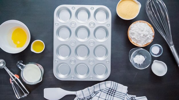 Schritt für Schritt. Cupcake-Pfanne aus Metall mit Butter zum Backen von Maisbrot-Muffins.