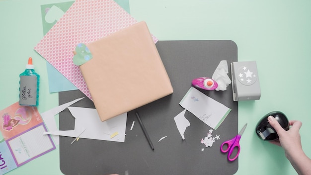 Schritt für Schritt. Geschenk zum Kindergeburtstag mit Bastelpapier dekorieren.