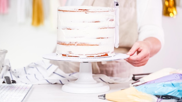 Schritt für Schritt. Konditor, der Einhornkuchen für kleine Mädchengeburtstagsfeier macht.