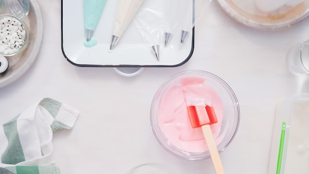 Schritt für Schritt. Mischen von Lebensmittelfarbe in Royal Icing, um Einhorn-Zuckerkekse zu dekorieren.