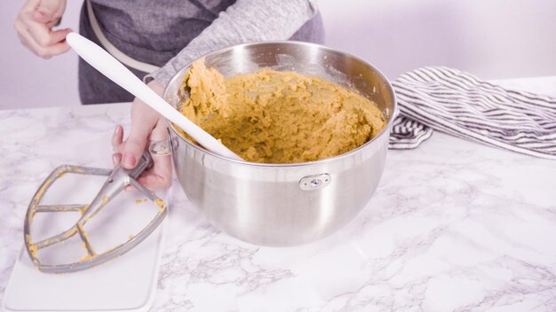 Schritt für Schritt. Mischen von Zutaten in stehendem Elektromixer zum Backen von Erdnussbutterkeksen.