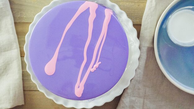 Schritt für Schritt. Pastre Shef macht Mousse-Kuchen mit lila Spiegelglasur und dekoriert mit schokoladenrosa Blüten.