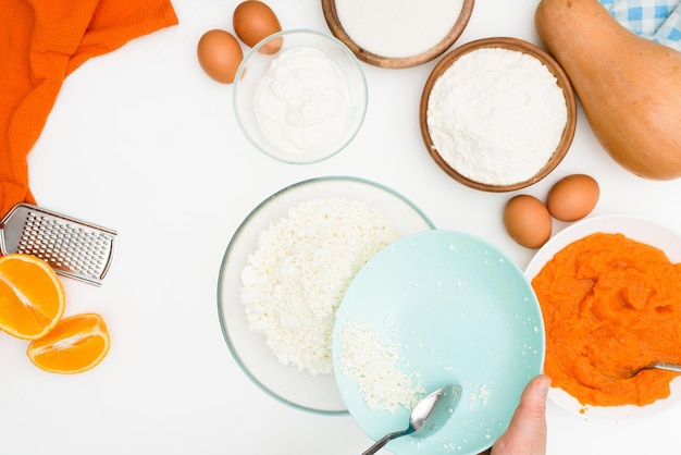 Schritt-für-Schritt-Rezept für Kürbisquark-Auflauf in Form eines Zebras, orangefarbener Herbstkuchen mit Orange. Mischen von Zutaten für Kürbiskuchen-Draufsicht. Mehl und Zucker zum Teig geben