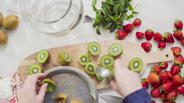 Schritt für Schritt. Schneiden von frischen Bio-Früchten für infundiertes Wasser.