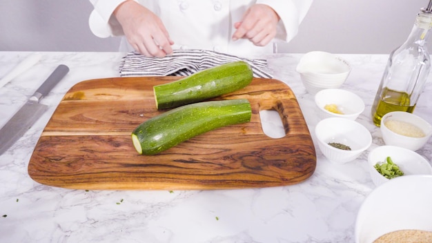 Schritt für Schritt. Schneiden von Zutaten für Zucchinikuchen mit Kräutersauerrahm.