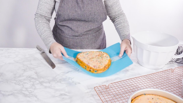 Schritt für Schritt. Verpacken Sie frisch gebackenen Funfetti-Kuchen in Zellophan und Kochfolie für die Aufbewahrung im Gefrierschrank.