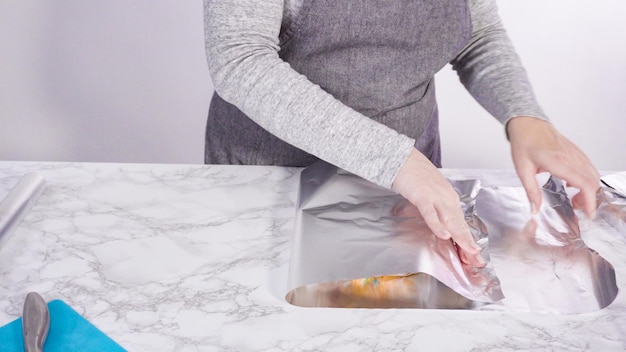Schritt für Schritt. Verpacken Sie frisch gebackenen Funfetti-Kuchen in Zellophan und Kochfolie für die Aufbewahrung im Gefrierschrank.