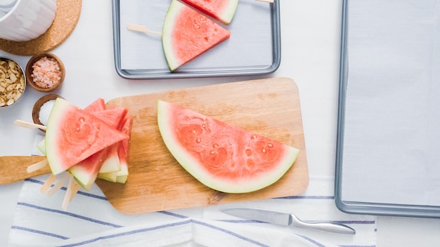 Schritt für Schritt. Wassermelone in Scheiben schneiden, um Wassermelonen-Eisknalle zu machen.