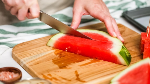 Schritt für Schritt. Wassermelone in Würfel schneiden, um Wassermelonenbissen mit Schokoladenüberzug zuzubereiten.