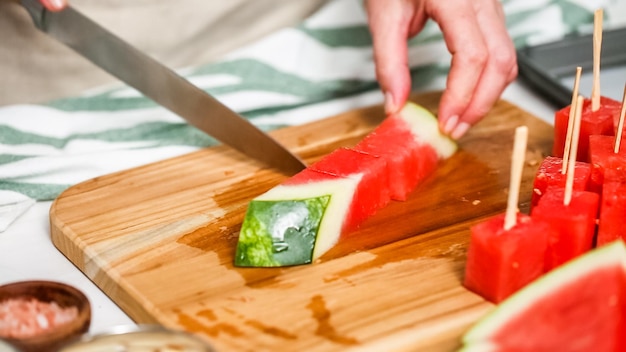 Schritt für Schritt. Wassermelone in Würfel schneiden, um Wassermelonenbissen mit Schokoladenüberzug zuzubereiten.
