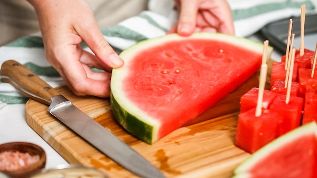 Schritt für Schritt. Wassermelone in Würfel schneiden, um Wassermelonenbissen mit Schokoladenüberzug zuzubereiten.