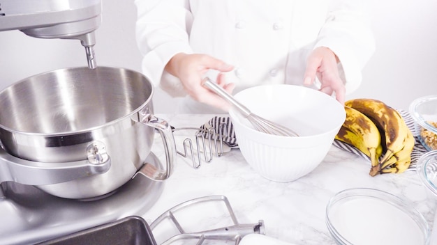 Schritt für Schritt. Zutaten in einer Rührschüssel aus Metall mischen, um Bananenbrot zu backen.