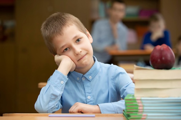 Schüler am Schreibtisch Junge im Klassenzimmer mit Büchern und einem Apfel Sekundarschule Zurück zur Schule