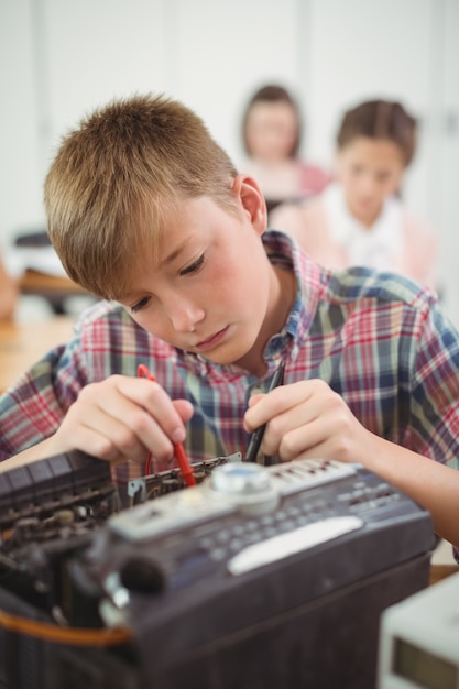 Schüler, der einen Drucker im Klassenzimmer repariert