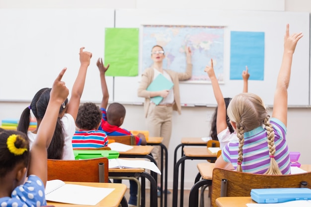 Foto schüler, die hand während der geografiestunde im klassenzimmer anheben