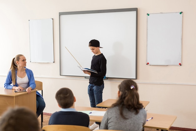 Schüler in der Nähe der Tafel mit einem Zeiger