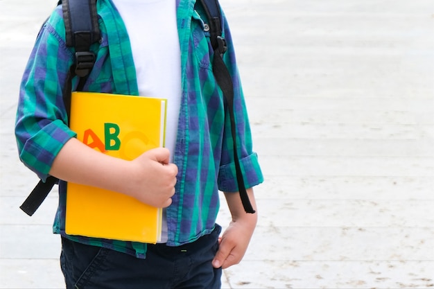 Schüler mit einem Buch in der Hand auf der Straße auf dem Weg zur Schule. Zurück zur Schule.