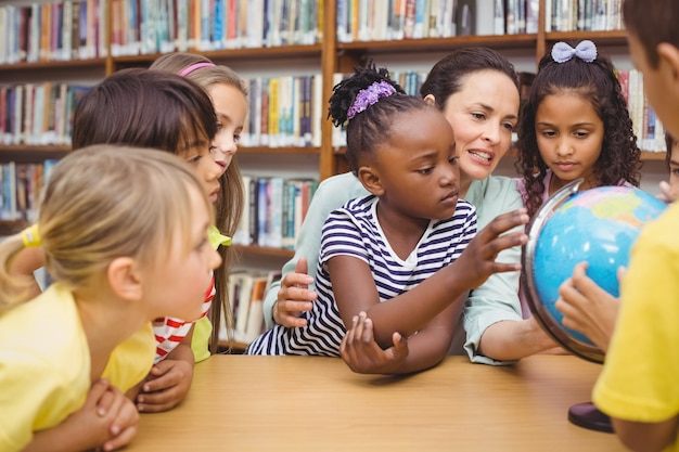 Schüler und Lehrer, die Kugel in der Bibliothek betrachten