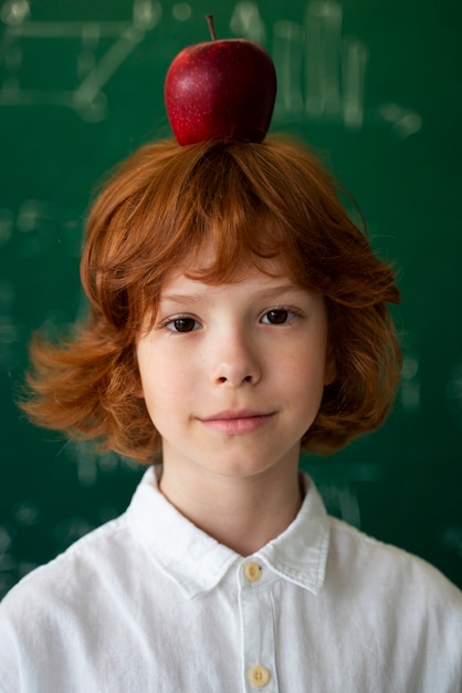 Schülerin in der Schule mit Apfel auf dem Kopf