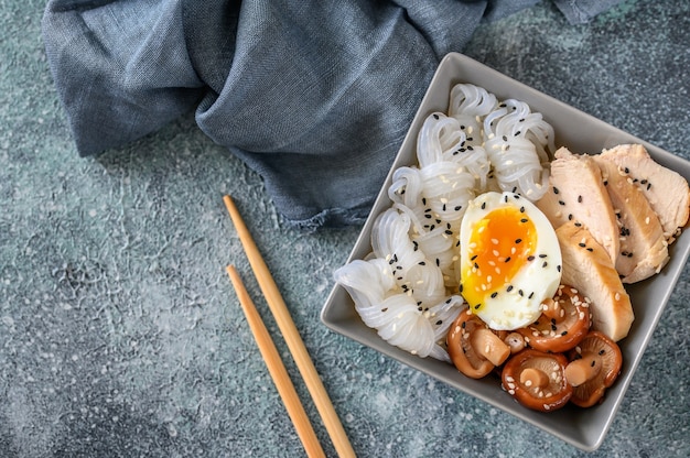 Schüssel asiatisches Essen mit Konnyaku, Hähnchenbrustscheiben, Shiitake und weich gekochtem Ei